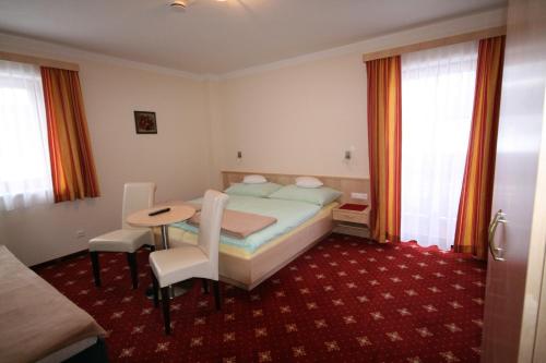 a hotel room with a bed and a table and chairs at Pension Thorerhof in Haus im Ennstal