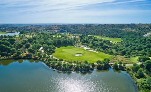 an aerial view of a golf course with a lake at Monte Rei Golf & Country Club in Vila Nova de Cacela