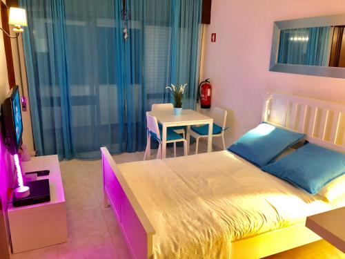 een slaapkamer met een bed en een tafel met stoelen bij Apartamento Praia do Alvor in Alvor