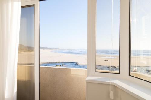 een badkamer met uitzicht op het strand vanuit een raam bij BestVillas Âncora Foz do Rio in Vila Praia de Âncora