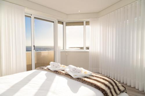 a bedroom with a bed with two towels on it at BestVillas Âncora Mar in Vila Praia de Âncora
