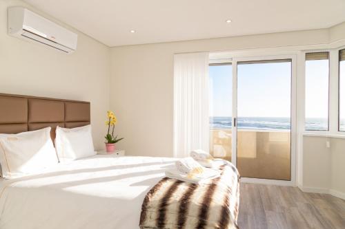een slaapkamer met een groot wit bed en een groot raam bij BestVillas Âncora Foz do Rio in Vila Praia de Âncora