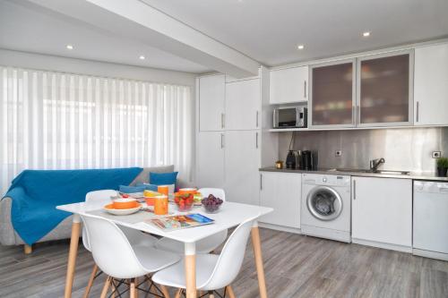 a kitchen and dining room with a white table and chairs at BestVillas Âncora Mar in Vila Praia de Âncora