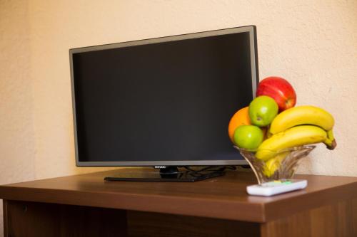 a television with a bowl of fruit on a table at Like Hotel in Novy Afon