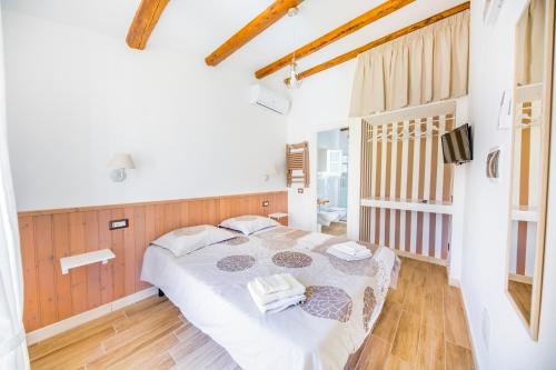 a bedroom with a white bed with white towels on it at Dafni e Naide in Cefalù