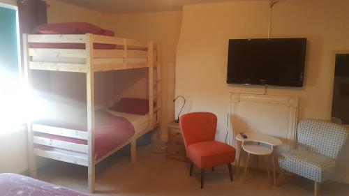 a bedroom with a bunk bed and a tv and a chair at Angel Guesthouse in Tiverton