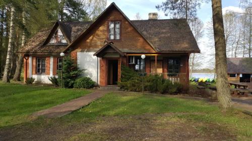 a house in the woods with a yard at Kempings Mežmalas in Usma