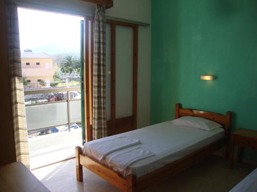 1 dormitorio con cama y ventana grande en Alex Apartments, en Rodas