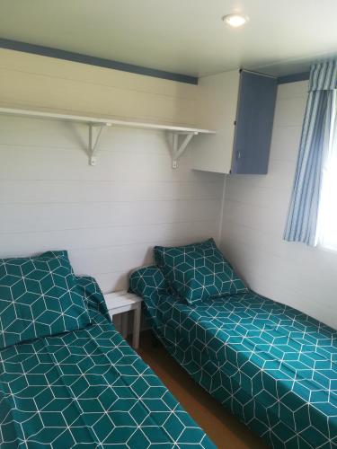 une petite chambre avec deux lits et une fenêtre dans l'établissement Les chalets de Bes 