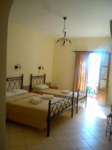 a bedroom with two beds and a large window at Archipelagos hotel in Koufonisia