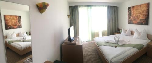 a hotel room with two beds and a television at Pirates Resort in Mamaia