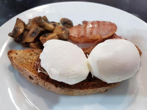 a plate of food with eggs and mushrooms on toast at Angel Guesthouse in Tiverton