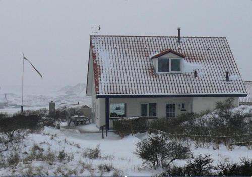 a house with a roof covered in snow at 't Zeepaardje in Midsland aan Zee
