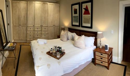 um quarto com uma grande cama branca e uma bandeja. em Dalton House em Cidade do Cabo