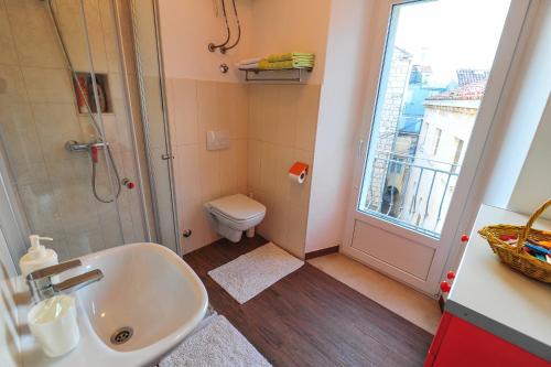 a bathroom with a sink and a toilet and a window at Apartment Punat in Korčula