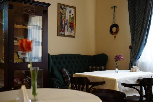 a dining room with a table and a green couch at Churchill-Inn in Vinnytsya