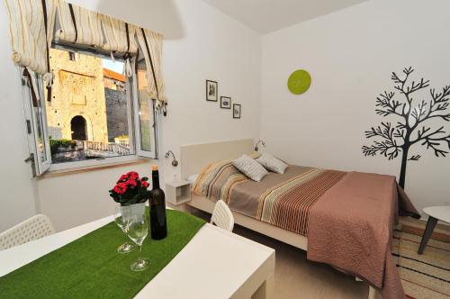 una camera da letto con un letto, un tavolo e una finestra di Apartment Punat a Korčula