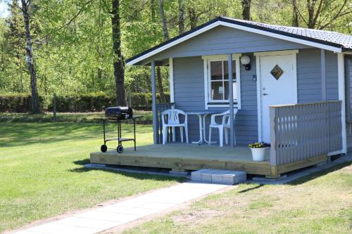 a blue tiny house with a table and a grill at Kärraton Stugor in Åhus