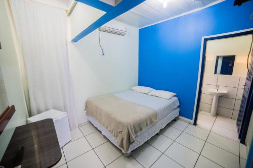 sypialnia z niebieską ścianą i łóżkiem w obiekcie Hotel Cielo w mieście Porto Velho