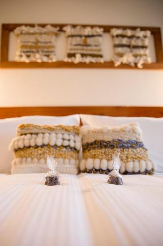 a bed with two pillows and two wedding rings on it at Maki Hotel in Pucón