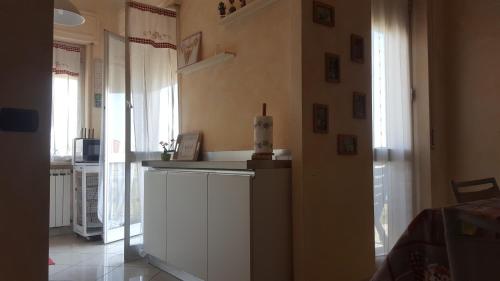 a kitchen with a white counter and some windows at Casa Di Marta in Diano Marina