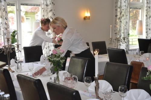 a couple of people standing at a table with flowers at Spånhults Herrgård Hotel in Norrahammar