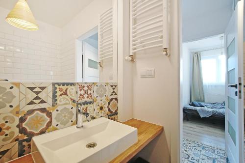 a bathroom with a white sink in a room at Przy Piastowskiej in Gdańsk