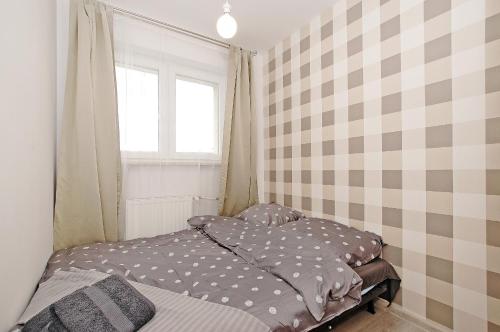 a small bedroom with a bed and a window at Przy Piastowskiej in Gdańsk