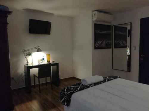 1 dormitorio con 1 cama y escritorio con lámpara en Hotel Boutique Valverde Santa Elena en San Salvador