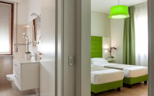 a bedroom with two beds and a green wall at Hotel Milano Palmanova in Milan