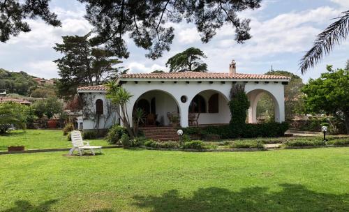 una casa bianca con un prato davanti di Villa Margherita a Cannigione