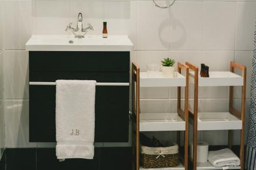 a bathroom with a sink and a green cabinet with towels at Casa Bouchon Hotel Boutique in San Javier