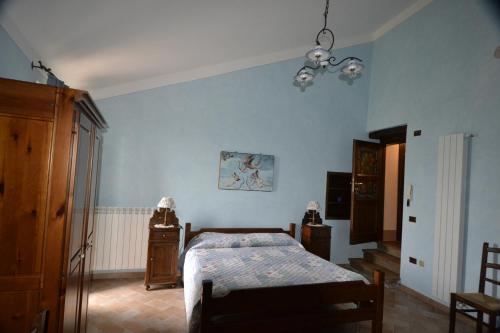 1 dormitorio con cama y pared azul en B&B FEDERICO II, en Montefalco