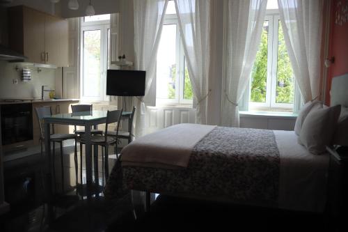 a bedroom with a bed and a kitchen with a table at Pinho Apartments, Studios and Rooms in Porto