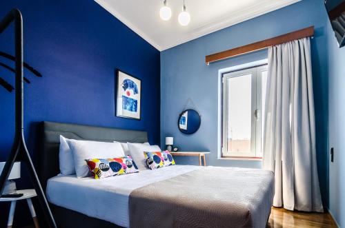 una camera blu con un letto e una finestra di Casa Ithomi a Chania