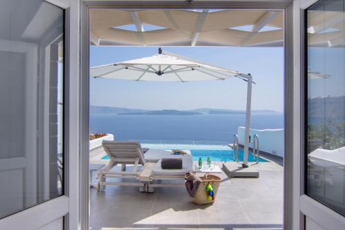 a patio with a view of the ocean from a house at Santorini Secret Suites & Spa, Small Luxury Hotels of the World in Oia