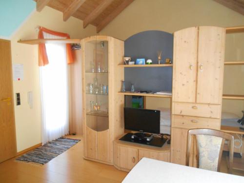 ein Wohnzimmer mit einem TV in einem Holzschrank in der Unterkunft Fewo-Sendelbach in Greußenheim