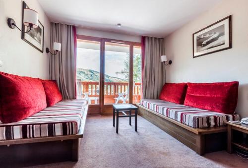 sala de estar con 2 sofás y balcón en Residence Albane - maeva Home en Vars