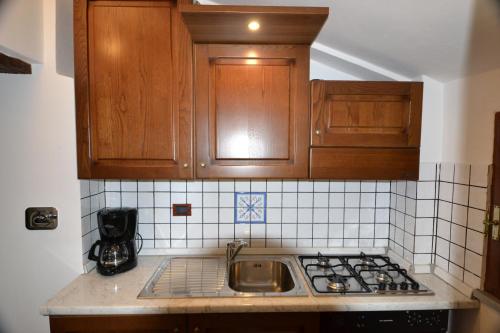 una cucina con armadi in legno, lavandino e piano di lavoro di B&B FEDERICO II a Montefalco