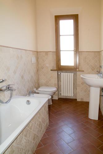 a bathroom with a tub and a toilet and a sink at Il Borgherino in Cerreto Guidi