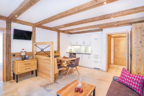 a living room with a table and a kitchen at Gaspingers Bergjuwel in Gerlos