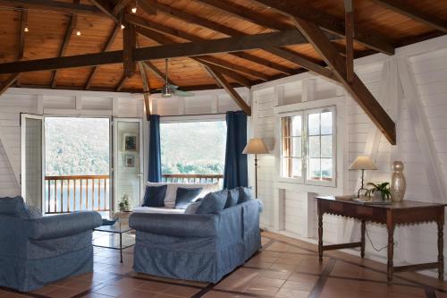 a living room with two blue chairs and a table at Villa Palm Bay Stunning View 5 min to beach 3 min to downtown King size bed in Deshaies