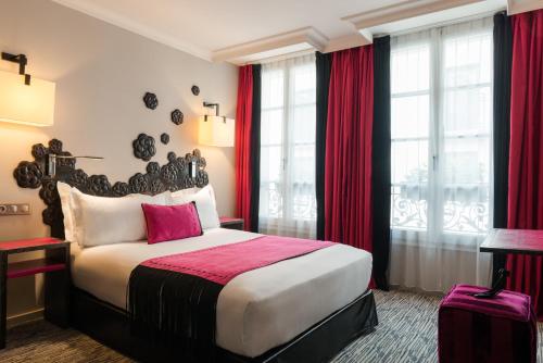 a bedroom with a large bed with red curtains at Les Jardins De La Villa in Paris
