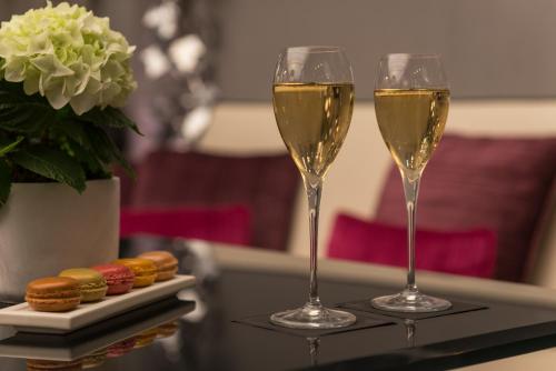 two glasses of white wine sitting on a table at Les Jardins De La Villa in Paris