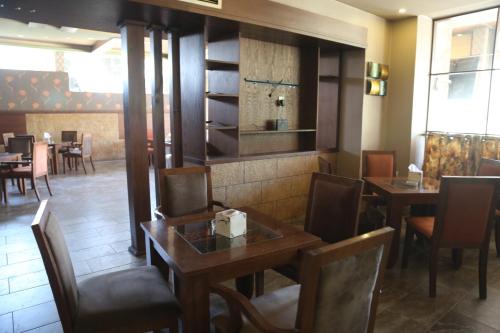 a dining room with two tables and chairs in a restaurant at Rozana Hotel in Amman