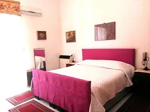 a bedroom with a large bed with a purple blanket at La Corte di Zaccaria in Mazara del Vallo
