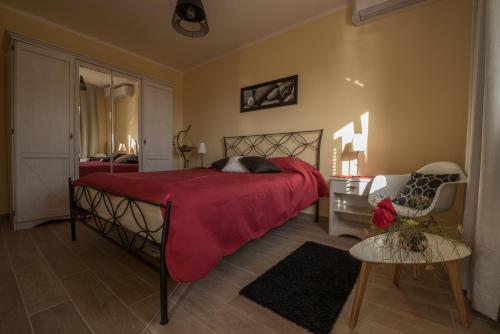 a bedroom with a bed with a red blanket and a chair at Villa Sunset in Jadranovo