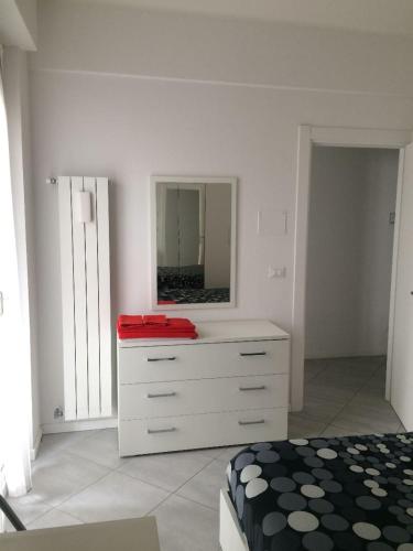 a bedroom with a bed and a dresser with a mirror at Appartamento sul porto in Loano