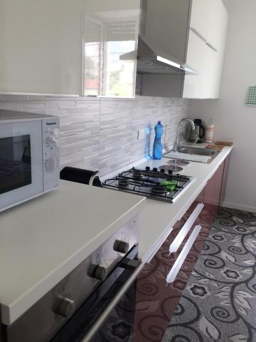 a kitchen with a counter with a stove and a microwave at Appartamento sul porto in Loano