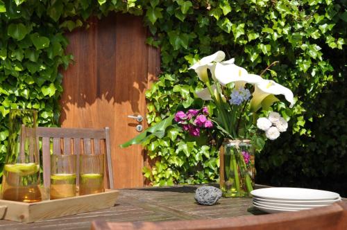 une table avec un vase de fleurs et de assiettes dans l'établissement Casa Rural Doña Herminda, à La Matanza de Acentejo